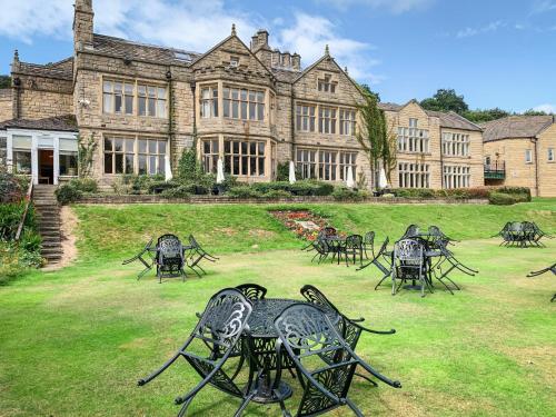 a large building with tables and chairs in the yard at Hollins Hall Hotel, Golf & Country Club in Bradford