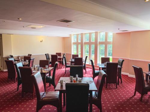 a restaurant with tables and chairs in a room at Hollins Hall Hotel, Golf & Country Club in Bradford