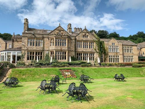 a large building with chairs in front of it at Hollins Hall Hotel, Golf & Country Club in Bradford