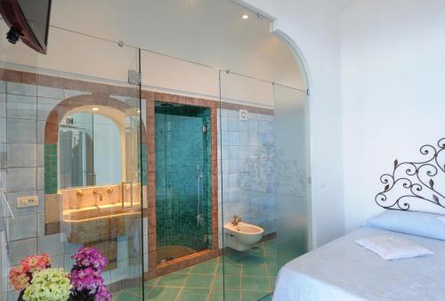 een badkamer met een douche, een wastafel en een toilet bij Fattoria La Tagliata in Positano