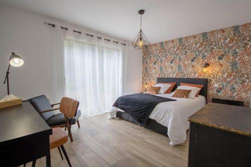 - une chambre avec un lit, une table et des chaises dans l'établissement Les Jardins du Cloestro, à Kervignac