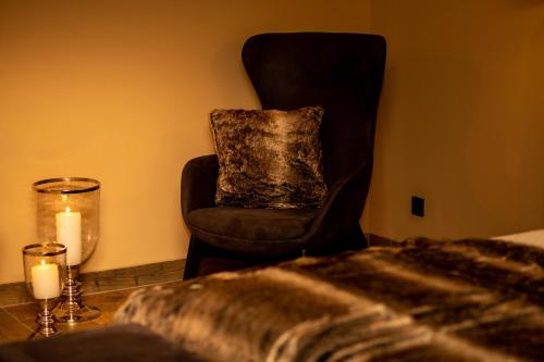 a bedroom with a chair and a candle and a bed at LUVA Resorts Kappl - Chalet K in Kappl