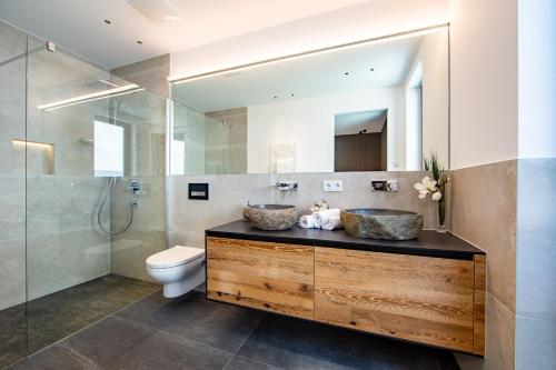 a bathroom with a sink and a toilet and a mirror at LUVA Resorts Kappl - Chalet K in Kappl
