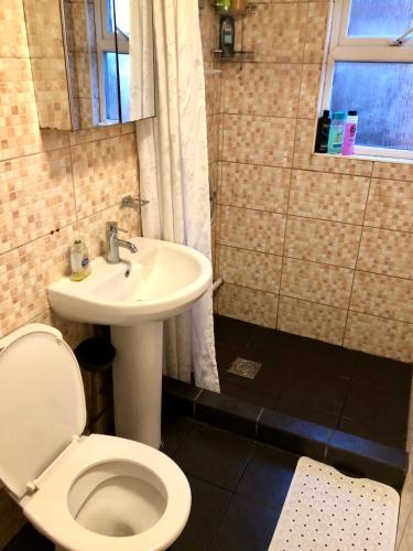 a bathroom with a toilet and a sink at The Guest House in Luton