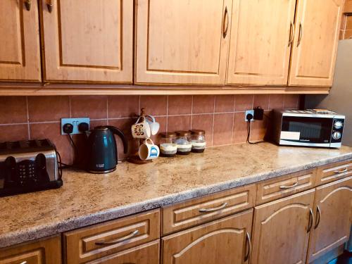 a kitchen counter with a toaster oven and a microwave at The Guest House in Luton
