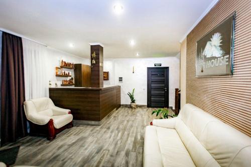 a living room with a white couch and two chairs at GORHouse Hotel in Yaremche