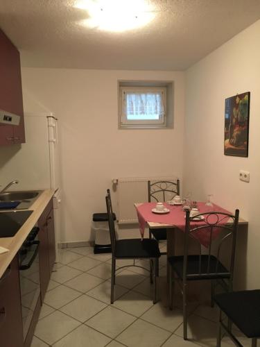 eine Küche mit einem Tisch und Stühlen im Zimmer in der Unterkunft Ferienwohnung Eibenweg in Gebsattel