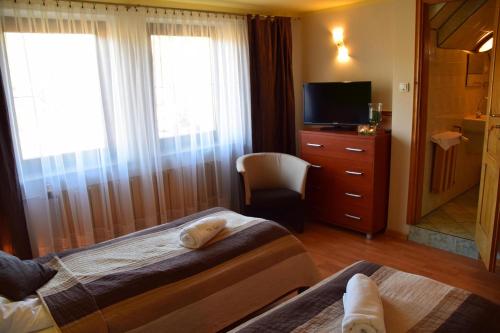 a hotel room with two beds and a television at Villa Goździk in Wisła