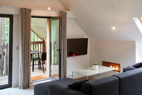 a living room with a couch and a fireplace at Tuddenham Mill Luxury Hotel in Tuddenham