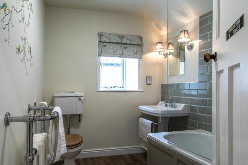uma casa de banho com um lavatório, um WC e uma banheira em Moors Inn em Appleton le Moors