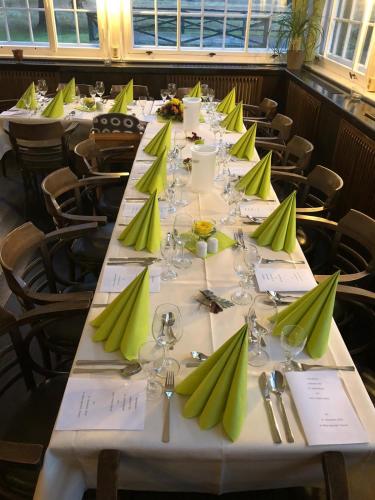 a long table with green napkins and wine glasses at Ferienhotel Alter Bahnhof garni in Prerow