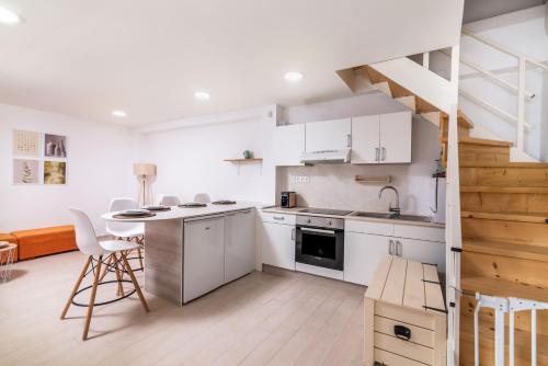 馬塔拉的住宿－Nikkon summer home，厨房配有白色橱柜和螺旋楼梯