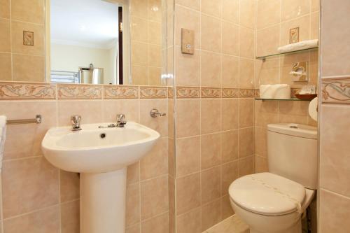 a bathroom with a sink and a toilet and a mirror at Burbage Holiday Lodge Apartment 5 in Blackpool