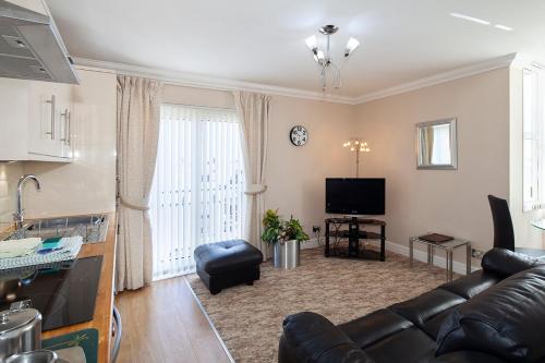 a living room with a couch and a tv at Burbage Holiday Lodge Apartment 5 in Blackpool