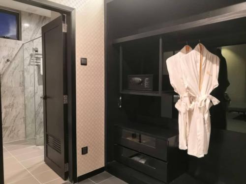 a bathroom with a white towel hanging from the wall at Vangohh Eminent Hotel & Spa in Bukit Mertajam