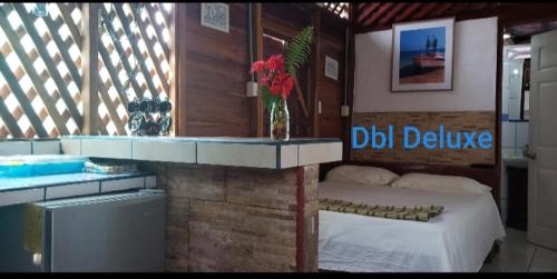 a bedroom with a bed and a vase of flowers on a counter at Hostal Cecilia in Puerto Viejo