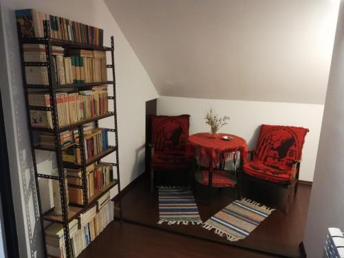 ブシュテニにあるBuşteni Houseの椅子2脚と本棚付きの部屋