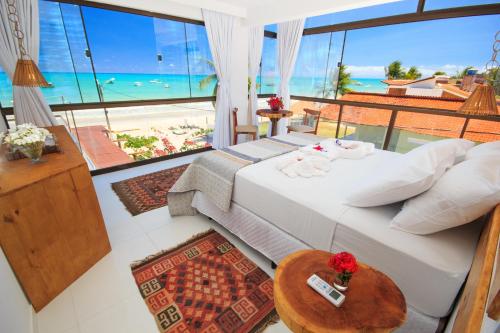 a bedroom with a bed and a view of the ocean at Ecohar Yoga (Vegetariano & Vegano) in Maragogi