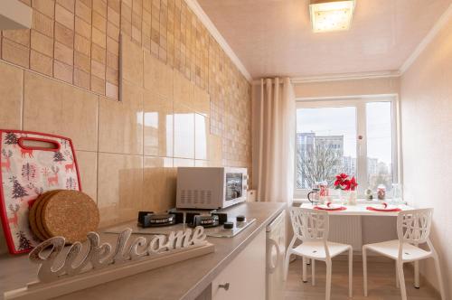 une cuisine avec une table et des chaises ainsi qu'une fenêtre dans l'établissement Akropole Apartment in Riga, à Riga