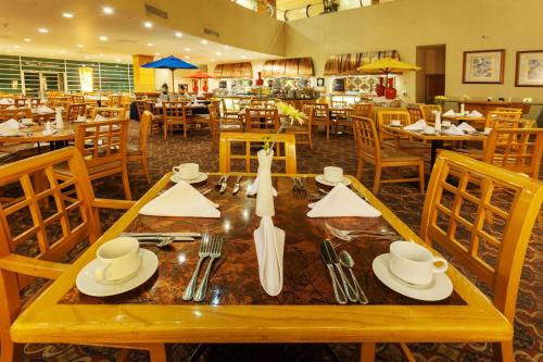 a restaurant with a wooden table with plates and utensils at Crowne Plaza Torreon by IHG in Torreón
