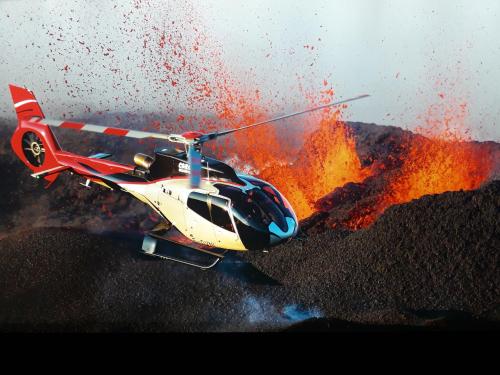 a red and white helicopter flying over a fire at Maison TONGA piscine - jacuzzi confort in Saint-Pierre