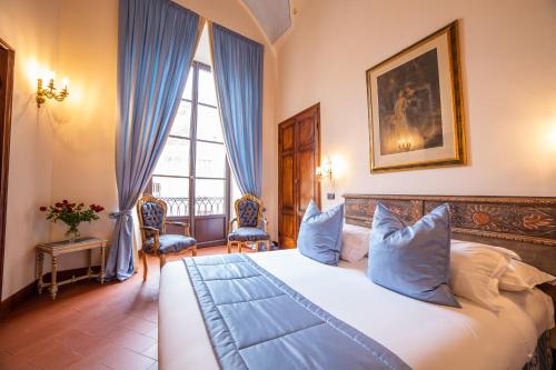 een slaapkamer met een groot wit bed met blauwe kussens bij B&B Galileo 2000 in Florence