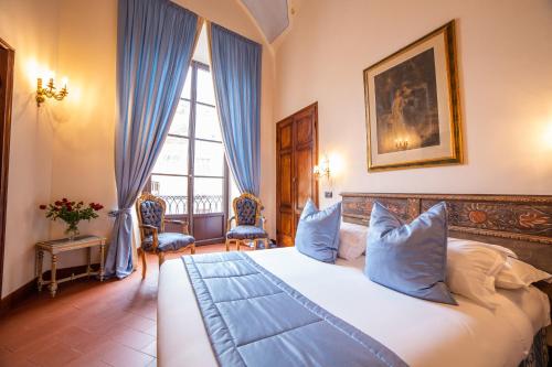a bedroom with a large white bed with blue pillows at B&B Galileo 2000 in Florence