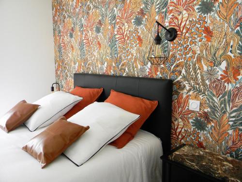 a bedroom with two beds with orange and white pillows at Les Jardins du Cloestro in Kervignac