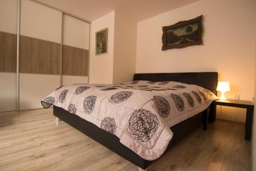 a bedroom with a bed and a table with a lamp at Apartmány Malý Princ in Bojnice