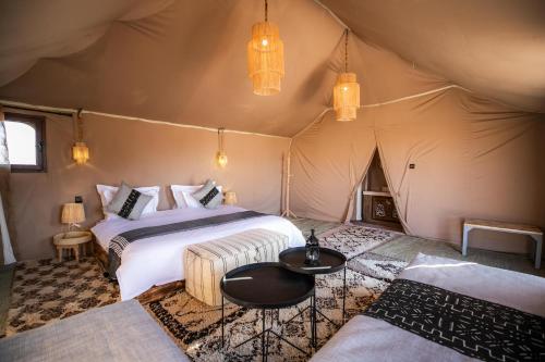 a bedroom with two beds in a tent at Aiour Luxury Camp in Merzouga
