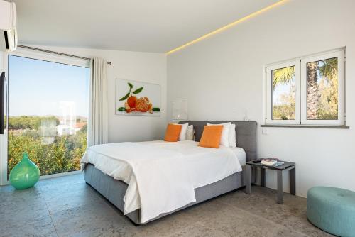 ein Schlafzimmer mit einem Bett und einem großen Fenster in der Unterkunft Vila Dria in Silves