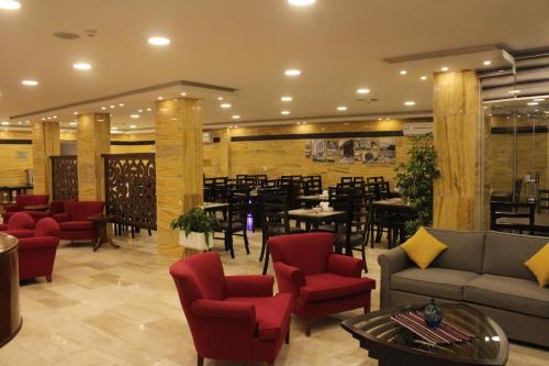 um restaurante com sofás, mesas e cadeiras em Petra Corner Hotel em Wadi Musa