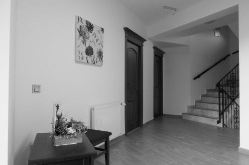 a hallway with a staircase and a table with flowers on it at Aqualina Colibita - pe malul lacului in Colibiţa