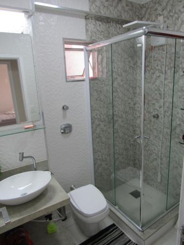 La salle de bains est pourvue d'une douche, de toilettes et d'un lavabo. dans l'établissement Apartamento Coral - 1 quadra do Mar, à Balneário Camboriú