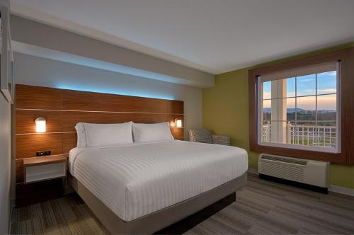 Un dormitorio con una cama grande y una ventana. en Holiday Inn Express Pigeon Forge – Sevierville by IHG, en Pigeon Forge