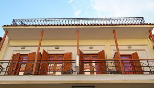 un balcón de una casa con persianas de madera en Sibylla Hotel, en Delfos