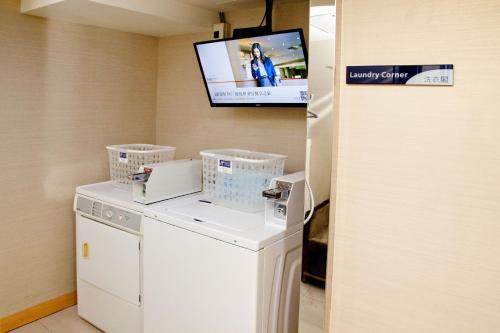 a room with a washing machine and a tv at Holiday Inn Express Taoyuan by IHG in Taoyuan