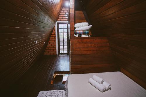an attic room with a bed with white towels at Chale da Mole in Florianópolis