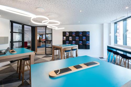 a room with a blue table with a surfboard on it at Holiday Inn Express - Rouen Centre - Rive Gauche by IHG in Rouen