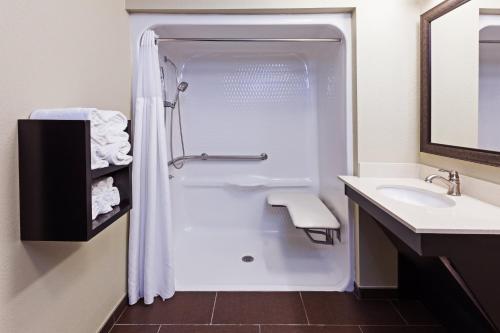 ein Bad mit einer Dusche und einem Waschbecken in der Unterkunft Staybridge Suites Tulsa-Woodland Hills, an IHG Hotel in Tulsa