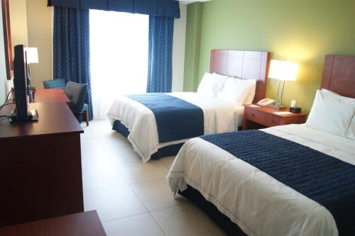a hotel room with two beds and a desk at Holiday Inn Express Veracruz Boca del Rio by IHG in Veracruz