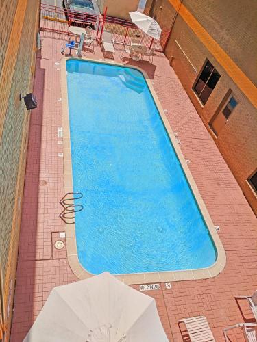 an overhead view of a large swimming pool with two umbrellas at Howard Johnson by Wyndham Houston Hobby Airport in Houston