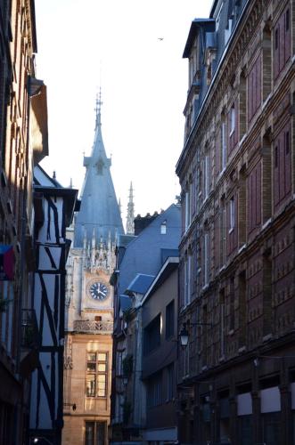 a building with a clock tower in the middle of a street at Holiday Inn Express - Rouen Centre - Rive Gauche by IHG in Rouen