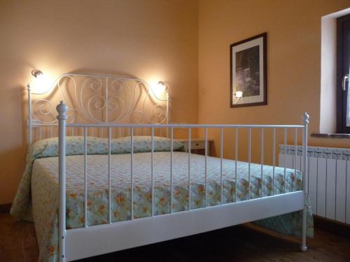 Un dormitorio con una cama blanca con dos luces. en Agriturismo Casale il Gallo Bianco en Offagna