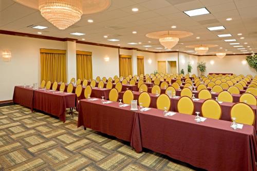 a conference room with tables and chairs and chandeliers at Wyndham Garden Totowa in Totowa