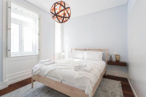 - une chambre blanche avec un grand lit et une fenêtre dans l'établissement FLH Luxury Flat near Marquês, à Lisbonne
