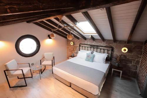 a bedroom with a large bed and a brick wall at Sukha Cunda Otel in Cunda