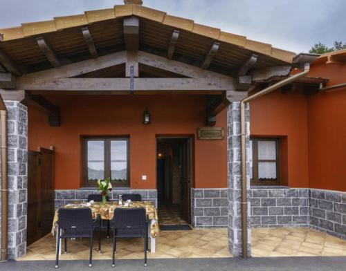 a patio with a table and chairs under a pergola at Apartamentos Miradorderodiles Miramar in Villaviciosa