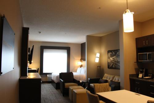 a hotel room with a bed and a table and chairs at Holiday Inn Express & Suites Cold Lake by IHG in Cold Lake