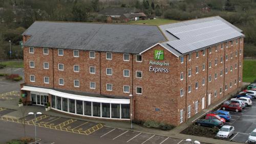 a large brick building with a truck parked in front of it at Holiday Inn Express Nuneaton, an IHG Hotel in Nuneaton